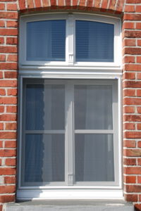 Fliegengitter Maßanfertigung vor einem Fenster mit schwarzem Stoffbezug.